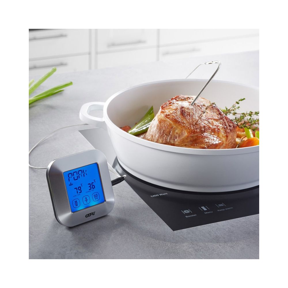 Ένα θερμόμετρο ψηφιακό μαγειρικής επάνω σε λευκό πάγκο με την ακίδα καρφωμένη σε κρέας