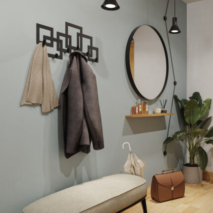 Μαύρη μεταλλική κρεμάστρα έξι θέσεων με σχέδιο κύβους τοποθετημένη σε τοίχο στο χωλ δίπλα από καθρέφτη