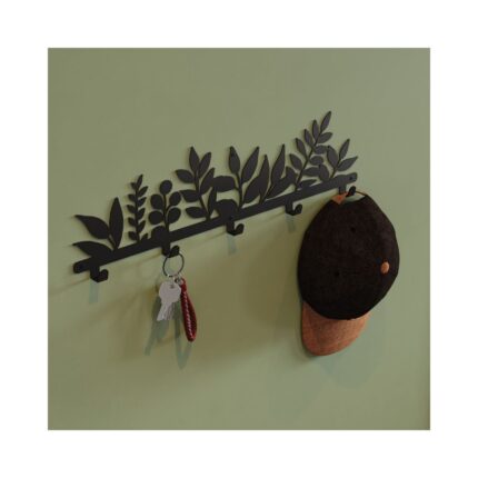 Μία διακοσμητική μαύρη μεταλλική κρεμάστρα σε χακί τοίχο με κρεμασμένο ένα καπέλο και κλειδιά