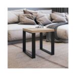 Ένα τραπεζάκι σαλονιού με μαύρα μεταλλικά πόδια και ξύλινη επιφάνεια