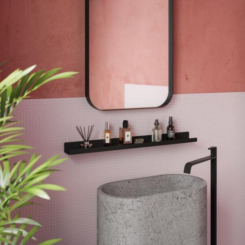 Ένα μαύρο μεταλλικό τετραγωνισμένο ράφι τοποθετημένο σε μπάνιο με ροζ αποχρώσεις