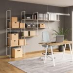 Ένας επαγγελματικό χώρος με ένα γραφείο και μία βιβλιοθήκη κατασκευασμένη με λευκές μεταλλικές δομές κατασκευής ραφιών