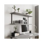 Ένα γραφείο με υπολογιστή και από πάνω δύο ράφια που στηρίζονται με δύο μαύρες μεταλλικές βάσεις